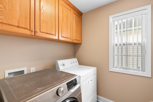 clothes washing area featuring cabinet space and separate washer and dryer
