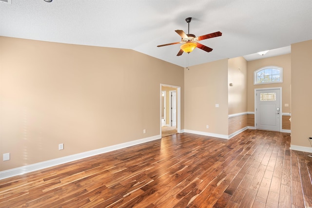 spare room with baseboards, lofted ceiling, ceiling fan, and dark wood-style flooring
