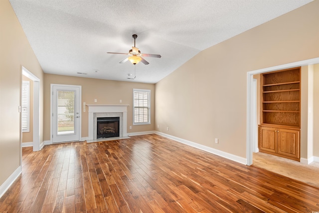 unfurnished living room featuring a textured ceiling, wood finished floors, and ceiling fan