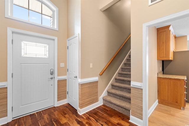 foyer featuring stairway, wood finished floors, and baseboards