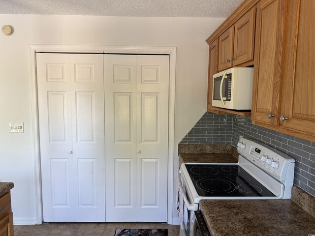 380-K Myrtle Greens Dr Unit 380-K, Conway, SC 29526 - kitchen featuring white appliances, brown cabinets, a textured ceiling, and decorative backsplash