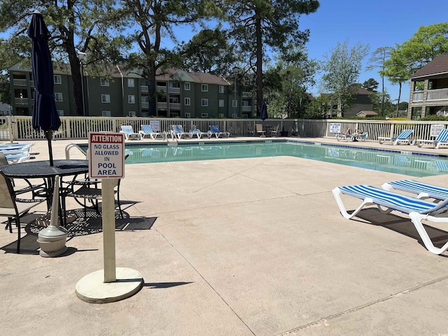 community pool featuring a patio area and fence