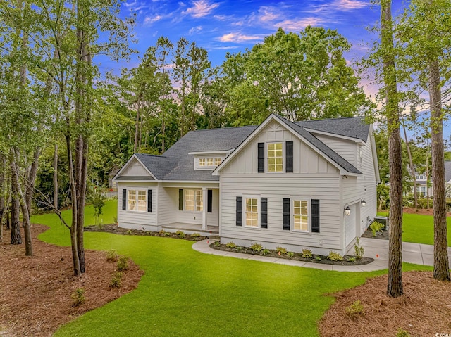 19 Coventry Pl, Pawleys Island, SC 29585 - view of front of house with board and batten siding, a front yard, roof with shingles, and driveway