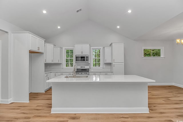 19 Coventry Pl, Pawleys Island, SC 29585 - kitchen featuring appliances with stainless steel finishes, a sink, light countertops, white cabinets, and a kitchen island with sink