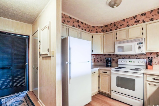 kitchen with crown molding, white appliances, light countertops, a textured ceiling, and light wood finished floors