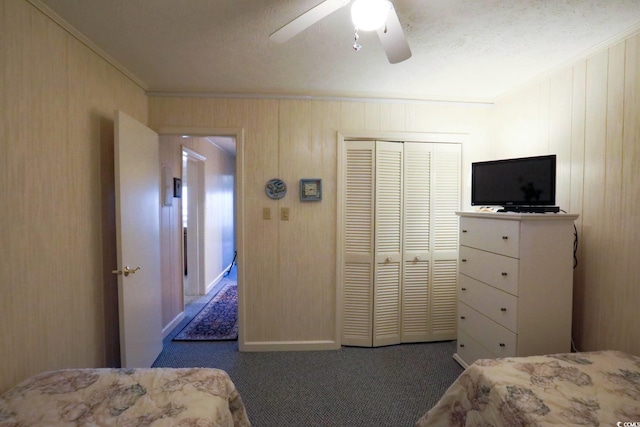 bedroom with a closet, ornamental molding, carpet, and a ceiling fan