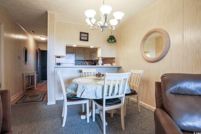 dining room with an inviting chandelier, carpet, and baseboards