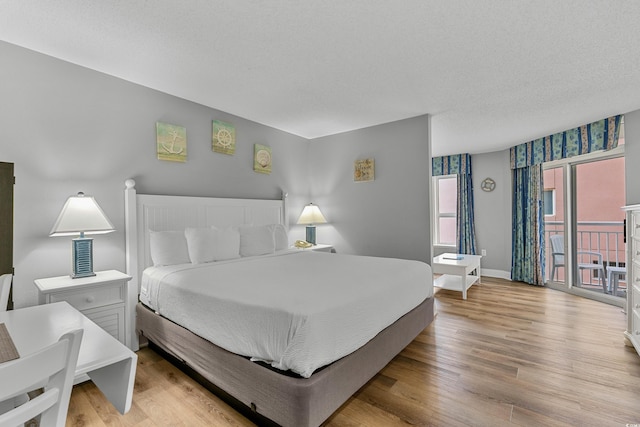 2801 S Ocean Blvd # 231, North Myrtle Beach, SC 29582 - bedroom featuring a textured ceiling, wood finished floors, access to outside, and baseboards