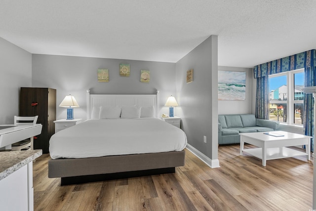 2801 S Ocean Blvd # 231, North Myrtle Beach, SC 29582 - bedroom with baseboards, a textured ceiling, and light wood finished floors