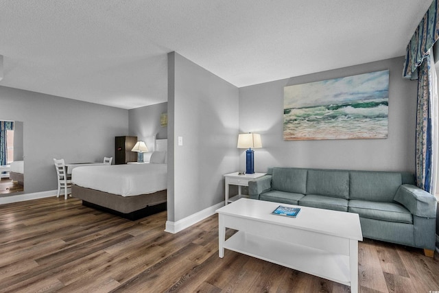 2801 S Ocean Blvd # 231, North Myrtle Beach, SC 29582 - living room featuring baseboards, wood finished floors, and a textured ceiling