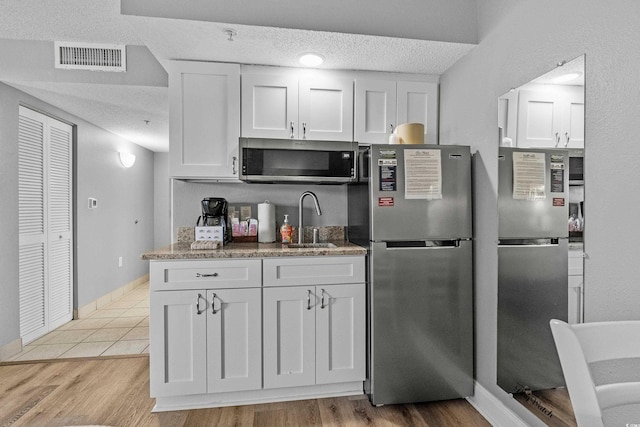 2801 S Ocean Blvd # 231, North Myrtle Beach, SC 29582 - kitchen with a sink, stainless steel appliances, visible vents, a textured ceiling, and white cabinets