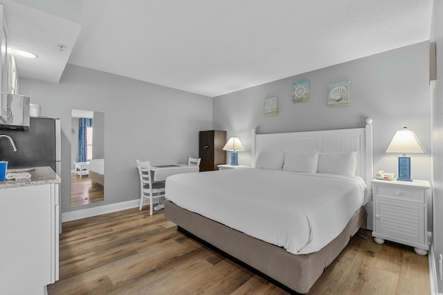 2801 S Ocean Blvd # 231, North Myrtle Beach, SC 29582 - bedroom featuring a sink, light wood finished floors, and baseboards