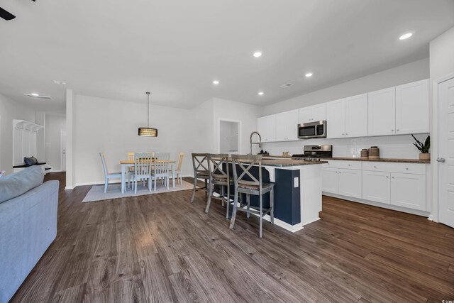 204 Leaflet Loop, Pawleys Island, SC 29585 - kitchen with stainless steel appliances, dark countertops, dark wood-type flooring, white cabinets, and recessed lighting