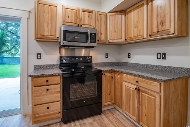 224 Oak Bay Dr, Georgetown, SC 29440 - kitchen featuring stainless steel microwave, black electric range oven, dark countertops, and light wood-style flooring
