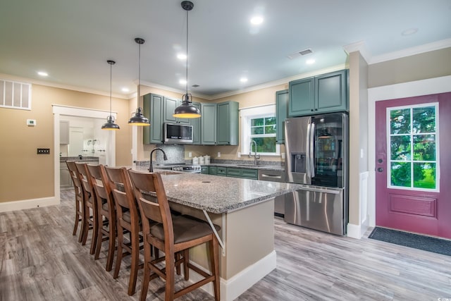 224 Oak Bay Dr, Georgetown, SC 29440 - kitchen with appliances with stainless steel finishes, a sink, crown molding, light stone countertops, and light wood finished floors