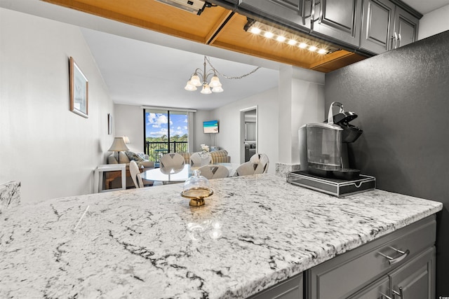 601 Mitchell Dr Unit 801, Myrtle Beach, SC 29577 - kitchen featuring gray cabinetry, open floor plan, a notable chandelier, and light stone countertops