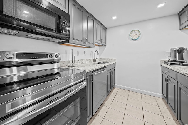 601 Mitchell Dr Unit 801, Myrtle Beach, SC 29577 - kitchen featuring appliances with stainless steel finishes, a sink, baseboards, gray cabinetry, and light stone counters