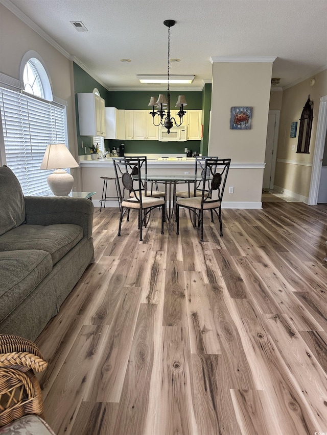 4639 Wild Iris Dr Unit 43-204, Myrtle Beach, SC 29577 - dining room with crown molding, light wood finished floors, a chandelier, and a textured ceiling