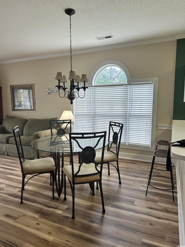 4639 Wild Iris Dr Unit 43-204, Myrtle Beach, SC 29577 - dining space with ornamental molding, wood finished floors, a chandelier, and a textured ceiling
