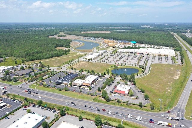 aerial view of property's location with a large body of water and a heavily wooded area