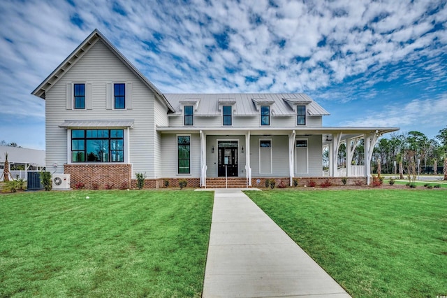 view of front of home with a standing seam roof, covered porch, a front lawn, and metal roof