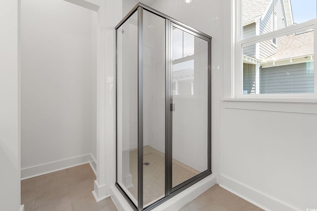 full bathroom featuring a stall shower, tile patterned floors, and baseboards