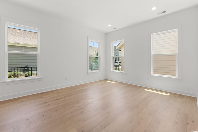 spare room with plenty of natural light, light wood-style flooring, baseboards, and recessed lighting
