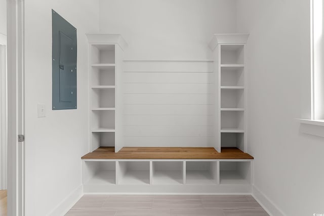 mudroom with electric panel and baseboards