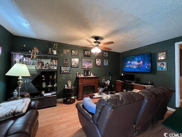 3641 Half Pint Rd, Longs, SC 29568 - living room with a textured ceiling, ceiling fan, wood finished floors, and a fireplace