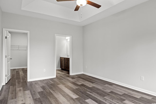 72 Millsite Ct, Georgetown, SC 29440 - unfurnished bedroom featuring a tray ceiling, dark wood-style flooring, a spacious closet, a closet, and baseboards