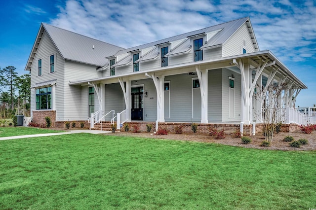 view of front of property featuring a porch, a front yard, central AC unit, metal roof, and brick siding