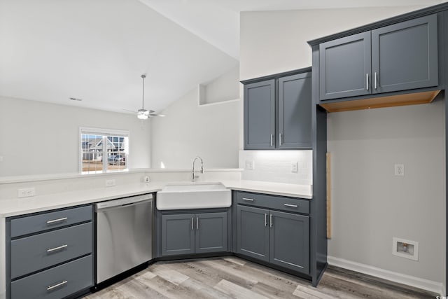 kitchen with stainless steel dishwasher, a sink, lofted ceiling, ceiling fan, and light wood-type flooring
