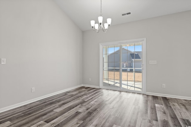 spare room with a chandelier, dark wood-style flooring, baseboards, and lofted ceiling