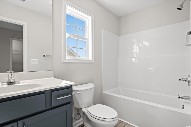 bathroom featuring toilet, vanity, and bathtub / shower combination
