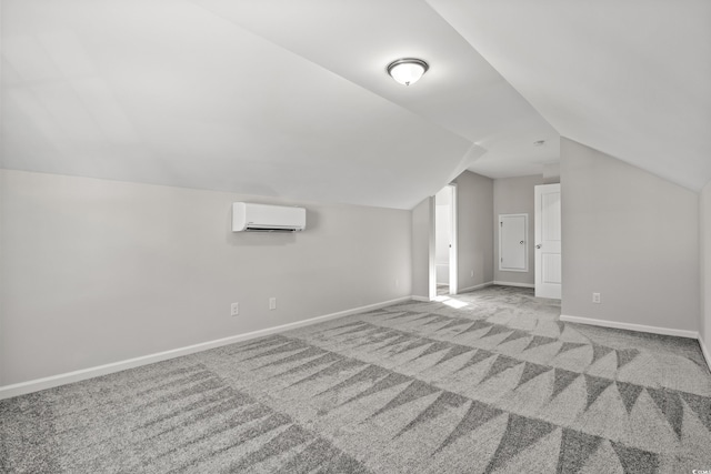 additional living space featuring a wall mounted air conditioner, lofted ceiling, carpet, and baseboards