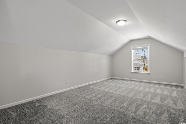 additional living space featuring carpet, lofted ceiling, and baseboards