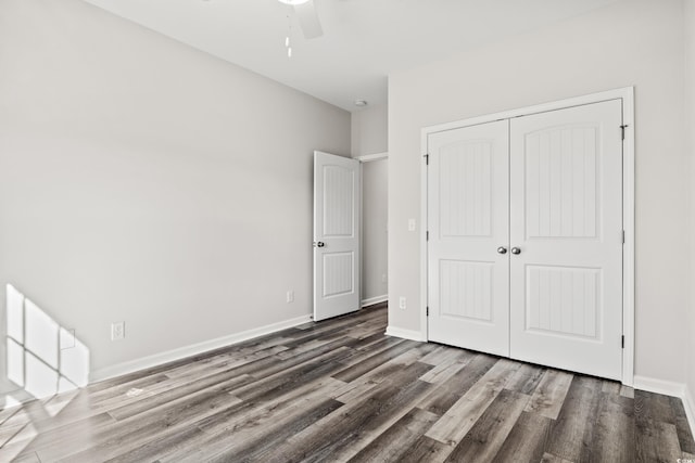 unfurnished bedroom featuring wood finished floors, a closet, baseboards, and a ceiling fan