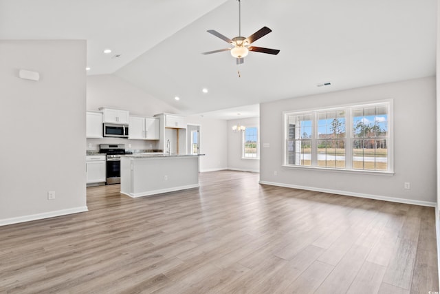 235 Six Mile Creek Dr, Georgetown, SC 29440 - unfurnished living room with light wood finished floors, ceiling fan with notable chandelier, high vaulted ceiling, and baseboards