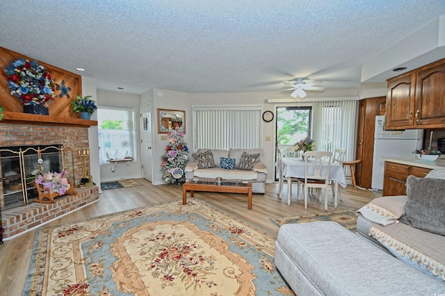 4242 Pinehurst Cir Unit N4, Little River, SC 29566 - living room featuring a textured ceiling, healthy amount of natural light, ceiling fan, light wood-style flooring, and a fireplace