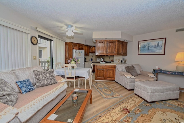 4242 Pinehurst Cir Unit N4, Little River, SC 29566 - living room featuring light wood-style floors, a ceiling fan, and a textured ceiling