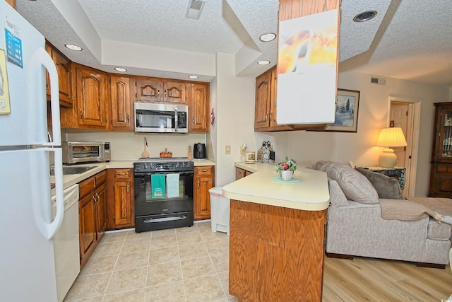 4242 Pinehurst Cir Unit N4, Little River, SC 29566 - kitchen with white appliances, a peninsula, open floor plan, brown cabinets, and a textured ceiling