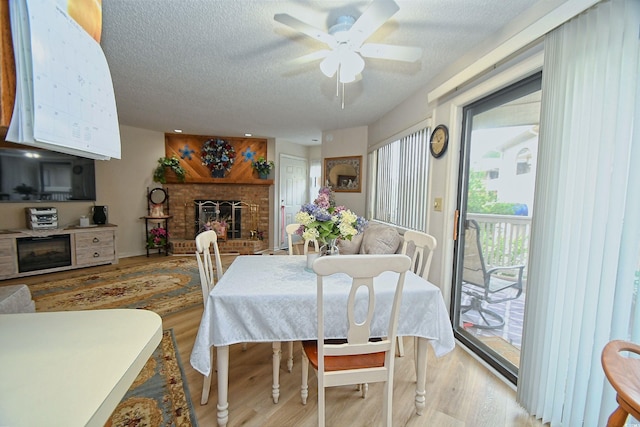 4242 Pinehurst Cir Unit N4, Little River, SC 29566 - dining space featuring a fireplace, ceiling fan, a textured ceiling, and light wood finished floors