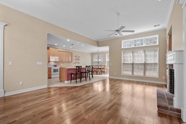 192 Berkshire Loop, Pawleys Island, SC 29585 - living room with ornamental molding, a ceiling fan, light wood-style floors, a fireplace with raised hearth, and recessed lighting