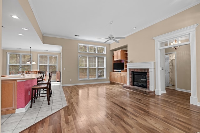 192 Berkshire Loop, Pawleys Island, SC 29585 - living area with light wood-type flooring, crown molding, ceiling fan, plenty of natural light, and a brick fireplace