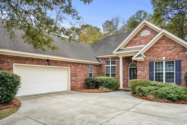 192 Berkshire Loop, Pawleys Island, SC 29585 - view of front of property with driveway, brick siding, a shingled roof, and an attached garage