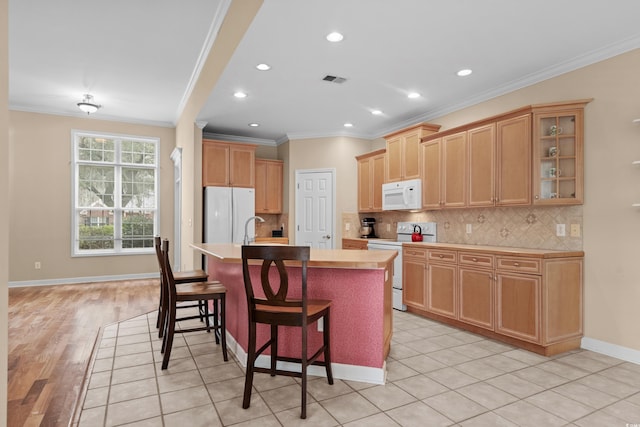 192 Berkshire Loop, Pawleys Island, SC 29585 - kitchen with white appliances, crown molding, light countertops, decorative backsplash, and a center island with sink