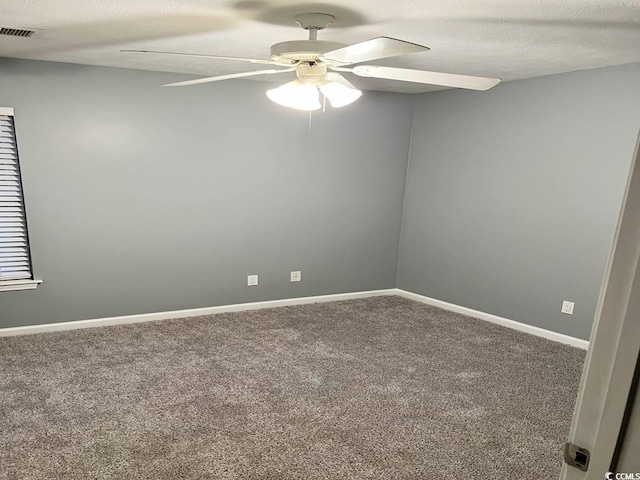 empty room with carpet floors, ceiling fan, baseboards, and a textured ceiling