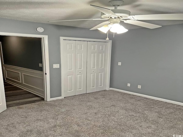unfurnished bedroom featuring carpet flooring, a closet, ceiling fan, and baseboards