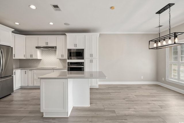 kitchen featuring crown molding, appliances with stainless steel finishes, a center island, baseboards, and visible vents