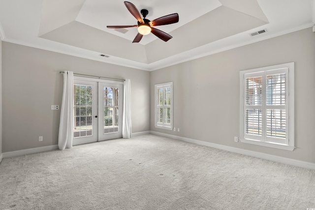 unfurnished room with french doors, a ceiling fan, baseboards, a tray ceiling, and visible vents